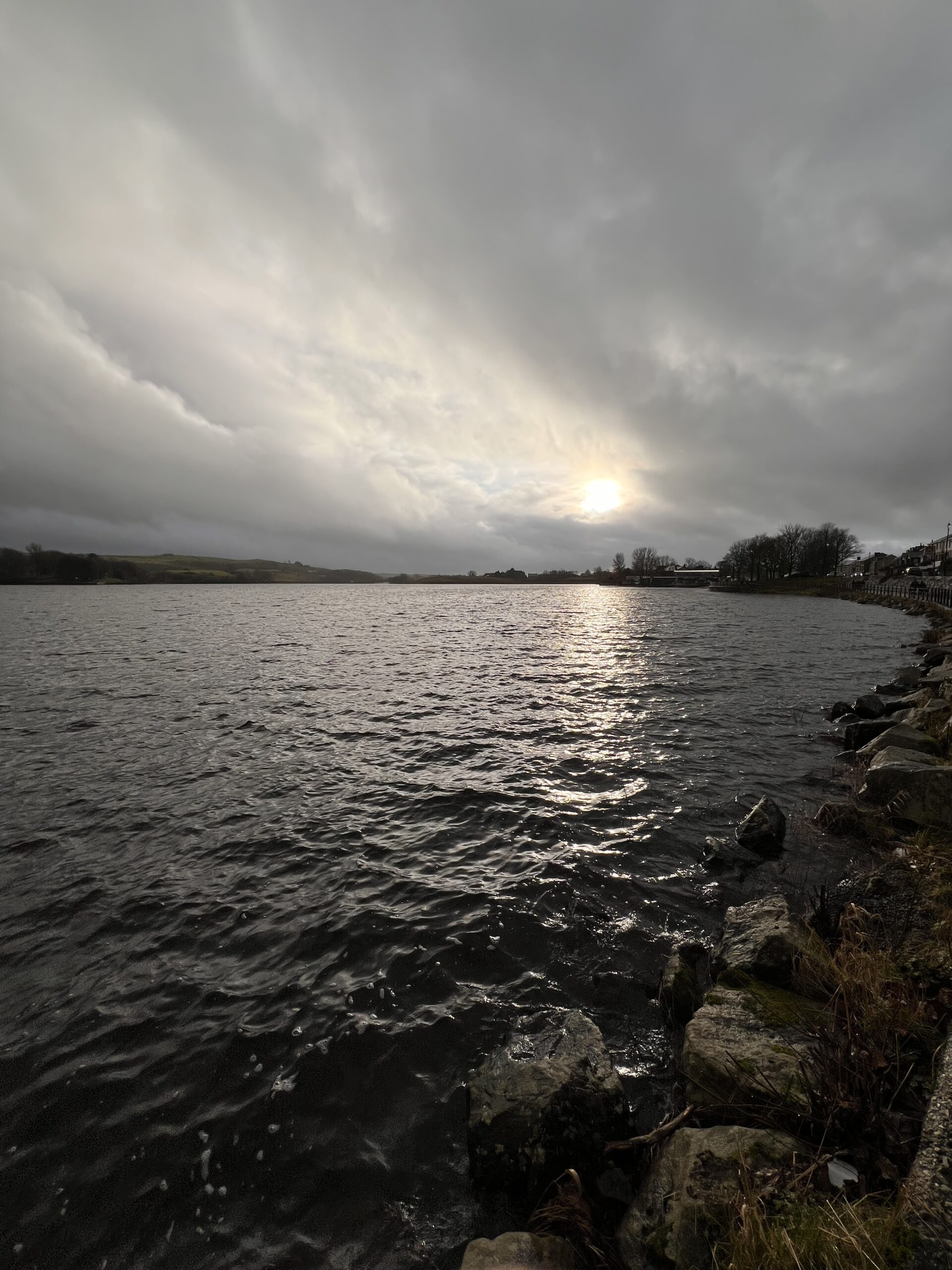 Sun shining through clouds over a lake