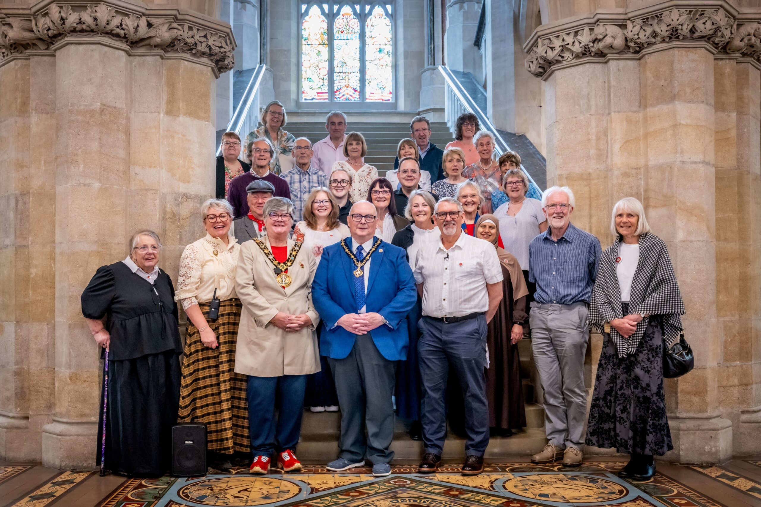 A photograph of Riverside writers in Rochdale Town Hall with the Mayor and participants posing by the main staircase