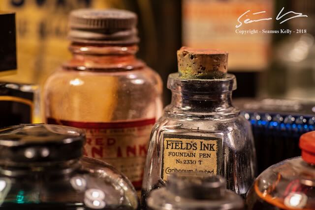 A photo of a collection of vintage ink bottles.